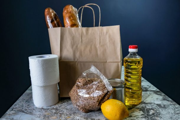 a bag with bread and samples of staple foods on a table