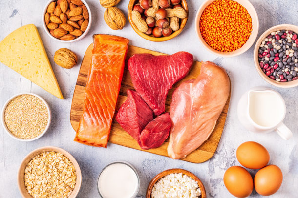 a serving board showing Sources of healthy protein - meat, fish, dairy products, nuts, legumes, and grains