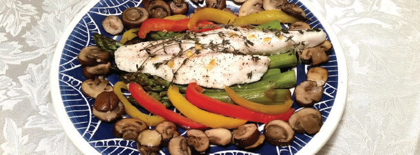 an image of a serving plate of baked fished surrounded by red and yellow peppers and mushrooms