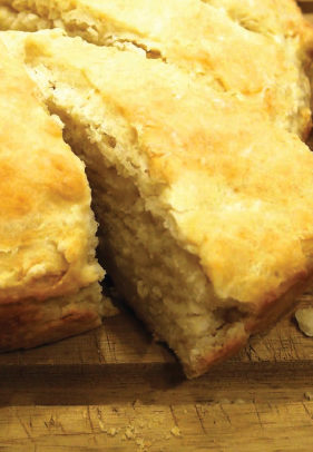 a close up image of a sliced bannock on a cutting board