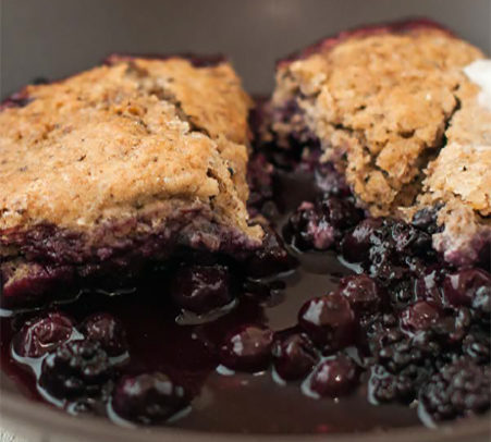 a photo of a pan of blueberry corn cobbler