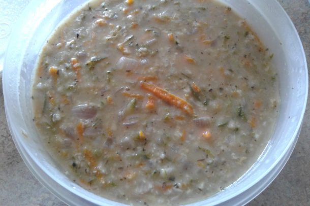 an image of a bowl of soup showing pieces of grated carrot and zucchini