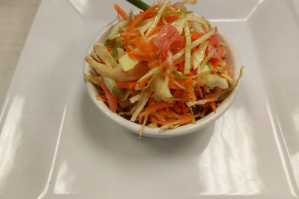 a serving bowl filled with crunch Asian coleslaw