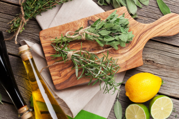 Fresh garden herbs and condiments on wooden table. Oregano, thyme, sage, rosemary. Top view