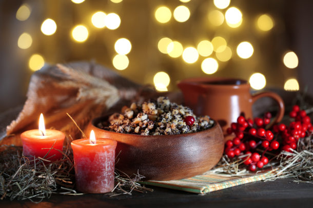 Bowl with kutia - traditional Christmas sweet meal in Ukraine, Belarus and Poland, on wooden table, on bright background