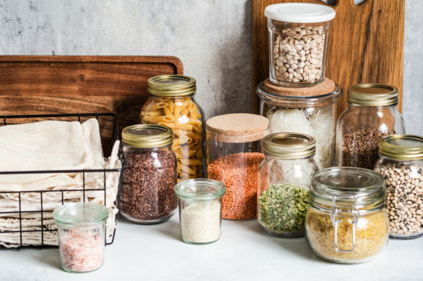 pantry staples in clear glass jars, legumes, spices, pasta