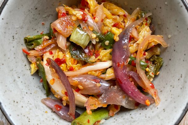 a bowl filled with kimchi - a mixture of cabbage, onions and chili flakes