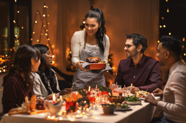 holidays and celebration concept - multiethnic group of happy friends having dinner at home